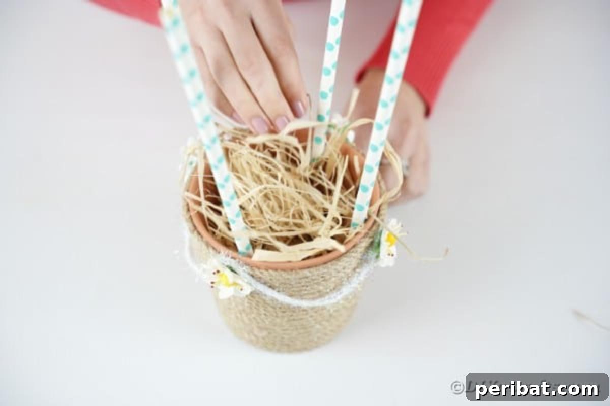 Hoppy Hot Air Balloon Easter Craft 13 Adding hay to the basket of the hot air balloon craft, preparing it for the bunny
