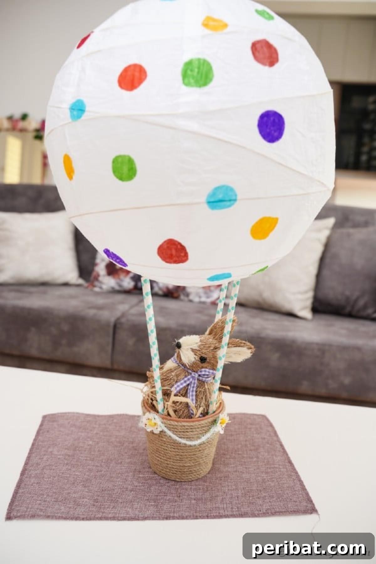 Hoppy Hot Air Balloon Easter Craft 4 Easter hot air balloon craft displayed on a table beside a couch, highlighting its versatility as a home decoration