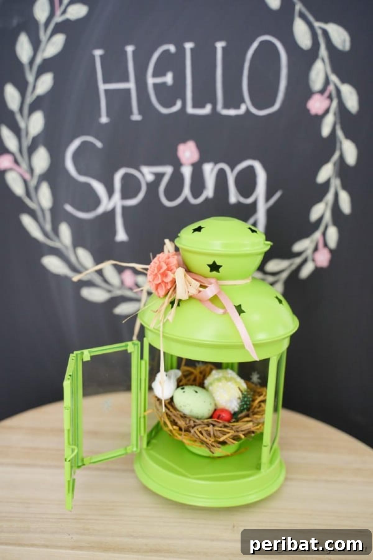 Green lantern with spring accents on table by chalkboard