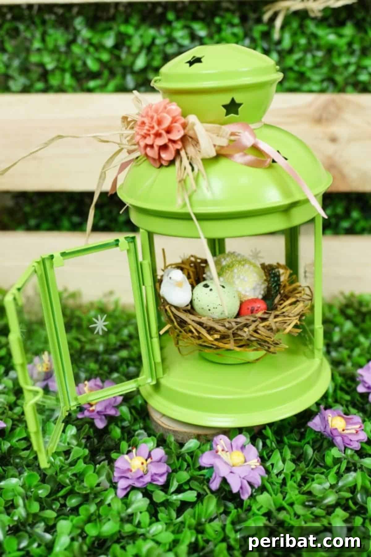 Green lantern Easter craft on grass by wooden box, showcasing spring decor