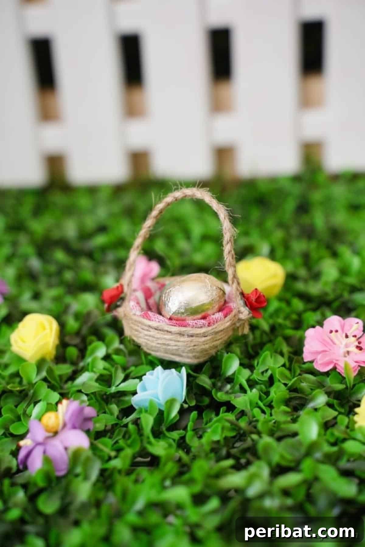 Egg carton Easter basket on grass in front of mini fence