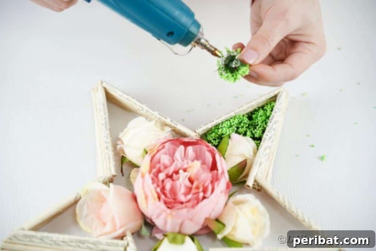Literary Starburst Wall Decor 17 Fake moss being glued around the artificial flowers in the star's center, filling gaps and adding texture.