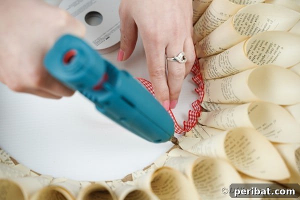 Aged Book Wreath Craft: Complete Video How-To 19 Gluing ribbon onto center of wreath