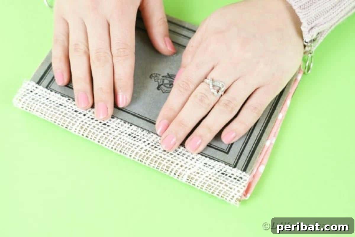 Old Books New Fashion DIY Book Purse Tutorial 13 Applying a strip of burlap ribbon along the bottom of the book cover to elegantly conceal the spine, adding a rustic touch to the upcycled purse design