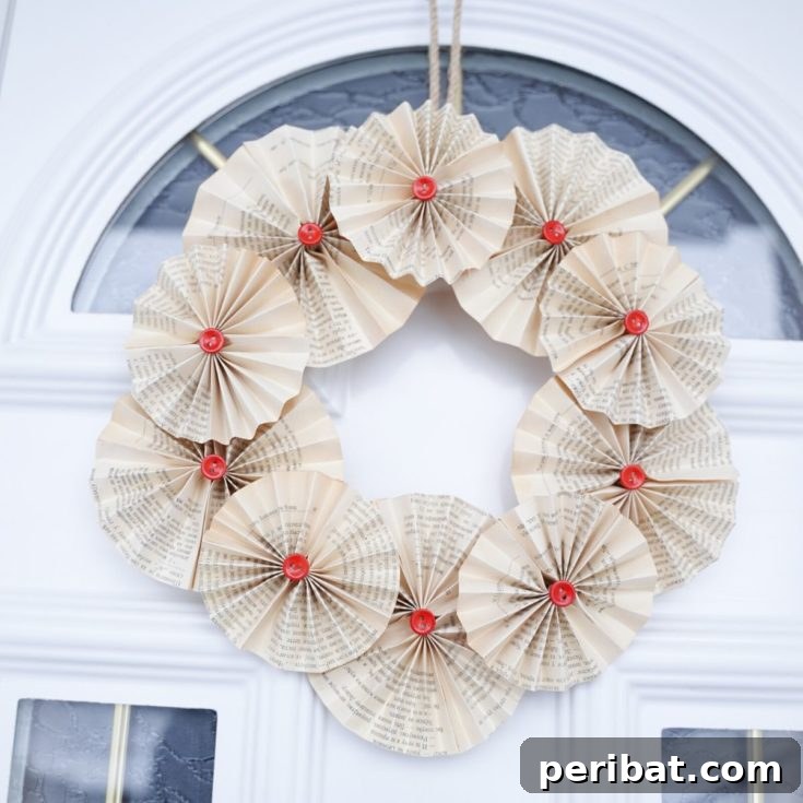 A stunning old book page wreath with red button accents, ready to be displayed.