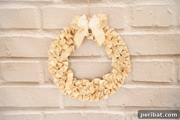 Another perspective of the rustic book page wreath, showcasing its full texture and depth against a brick background.