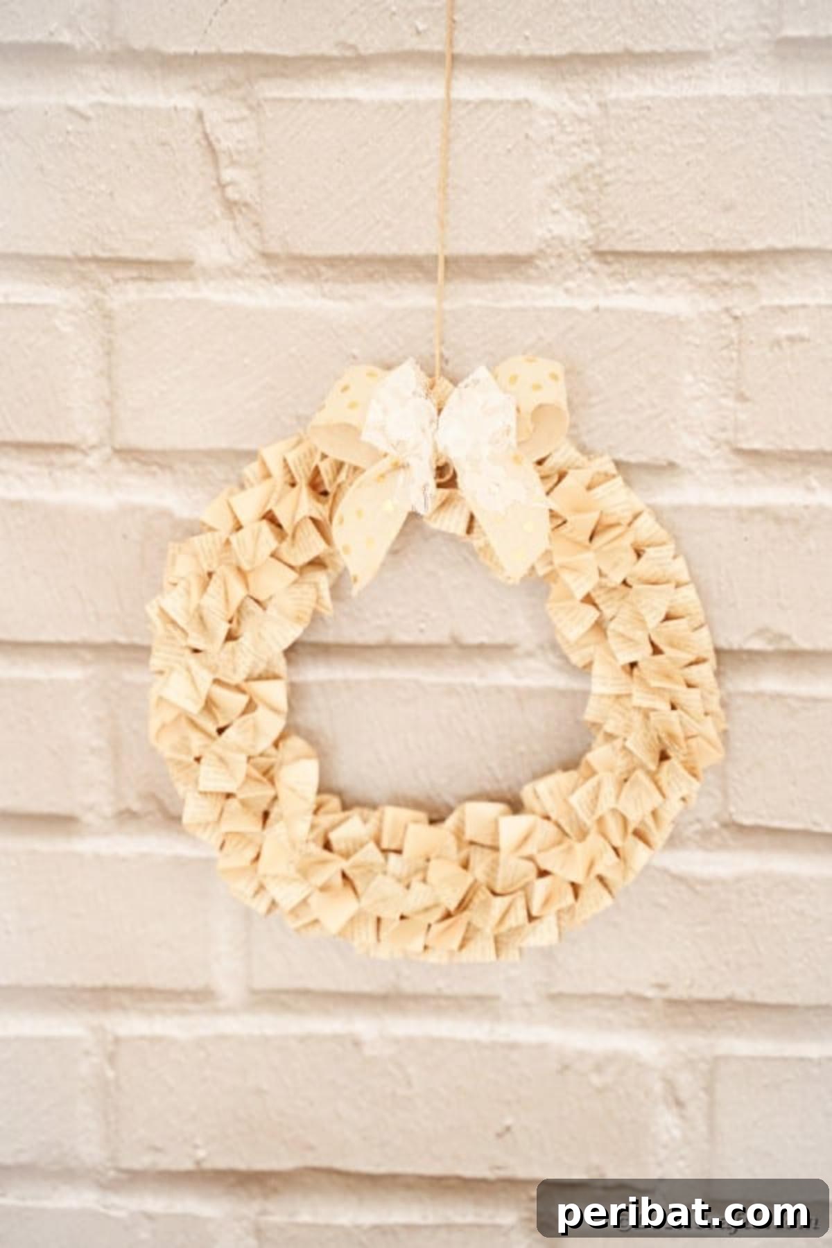 Rustic Origami Book Page Wreath on a textured brick wall, highlighting its versatile and timeless appeal.
