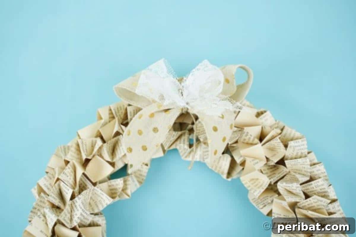 Close-up of the top portion of an Old Book Page Wreath, showcasing the intricate paper folds and a simple hanging ribbon.
