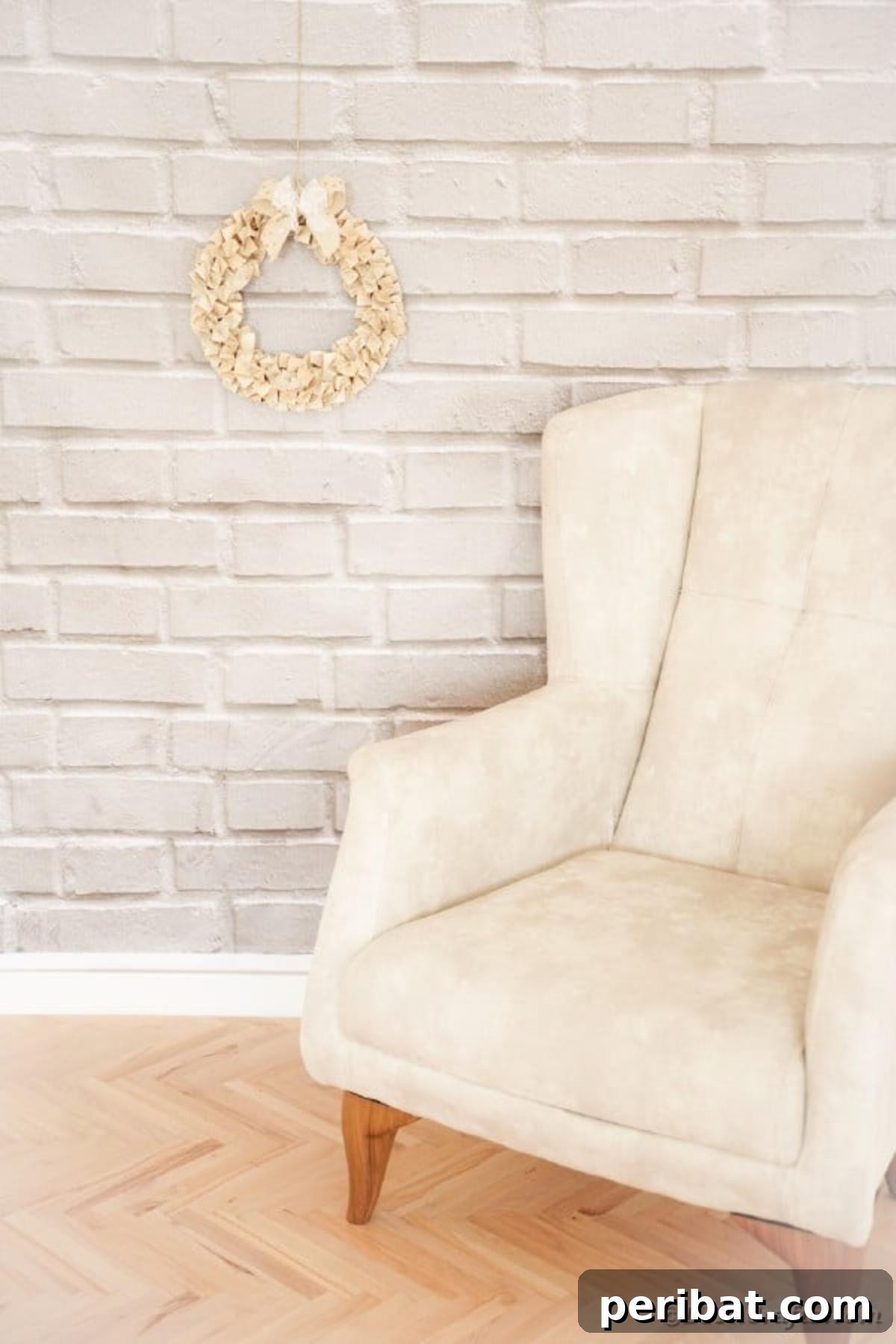 Elegantly crafted Book Page Wreath leaning against a brick wall next to a chair, ready for display.