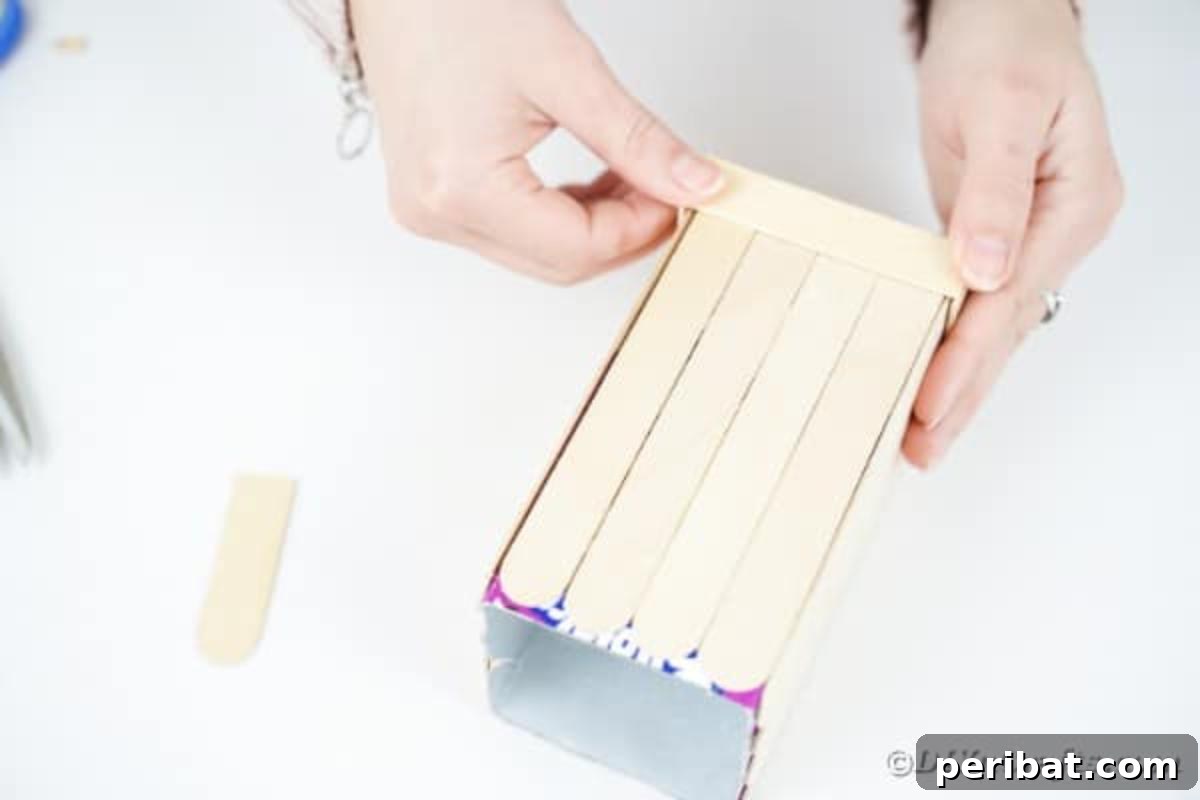 Craft Your Own Milk Carton Organizer Tutorial 11 Gluing craft sticks around the bottom of the milk carton