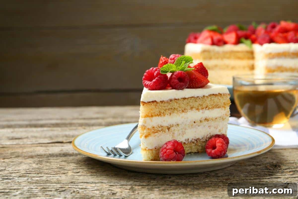 A delicious slice of berry cake topped with fresh berries, showcasing a baked item that can be frozen before decoration.