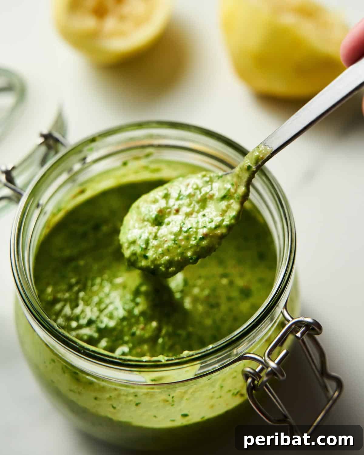 A jar full of vibrant green pesto, indicating its readiness for long-term freezer storage.