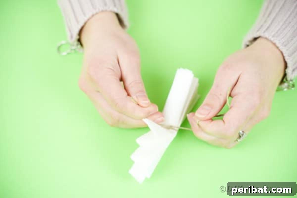 Tying twine around center of paper fan