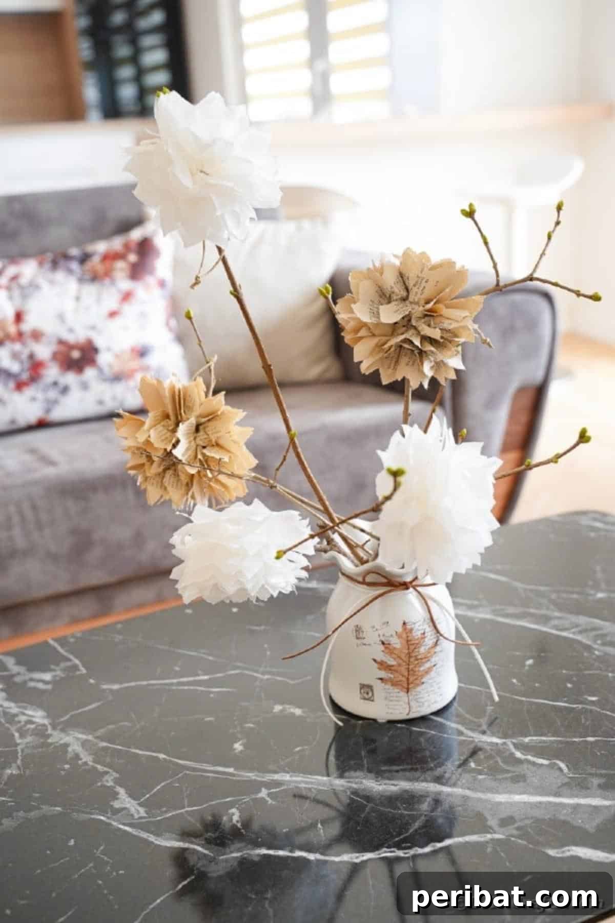 Small white container with rustic paper flower bouquet on marble table