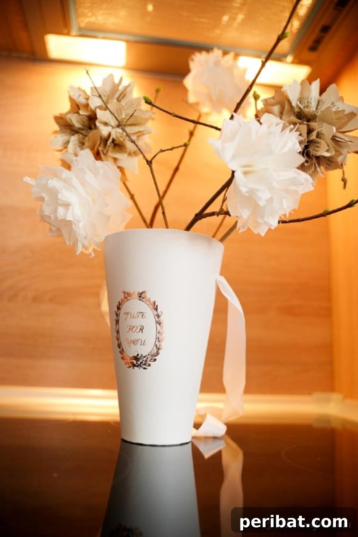 Cup filled with rustic paper flowers on table