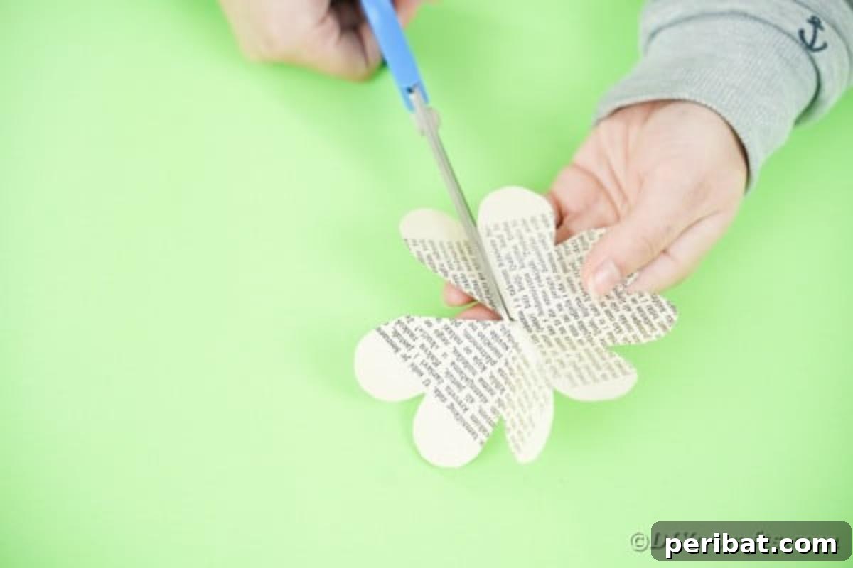 Hands cutting a single petal from a paper flower shape