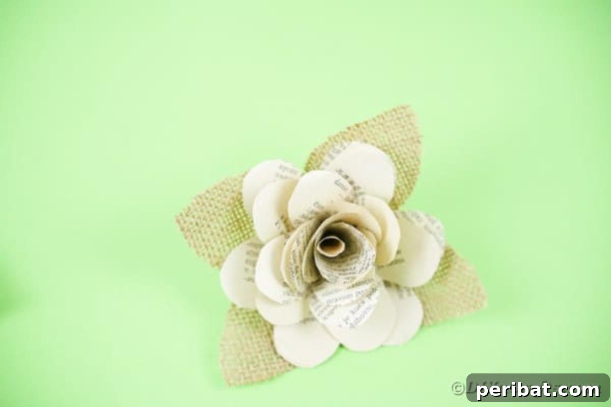 A completed paper flower with burlap leaves, ready for assembly