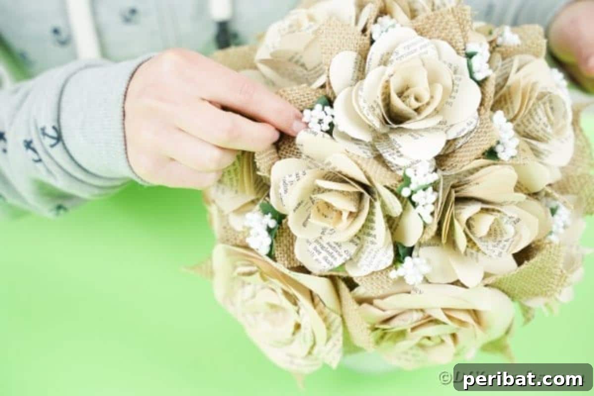 Hands gluing small artificial flowers into the paper rose bouquet