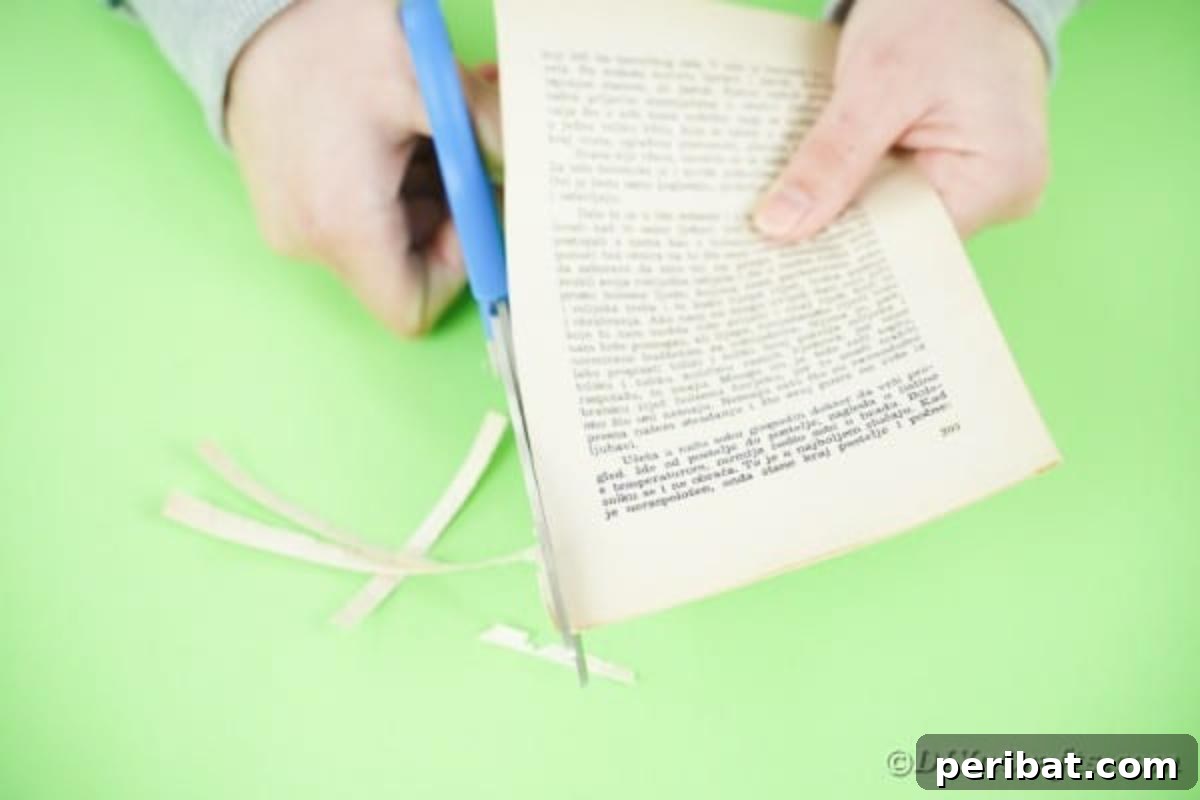 Close-up of hands cutting the edge off a book page