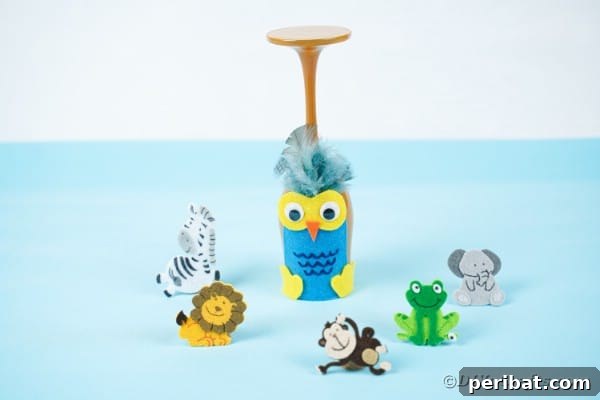 Wine glass owl on blue table surrounded by toy animals
