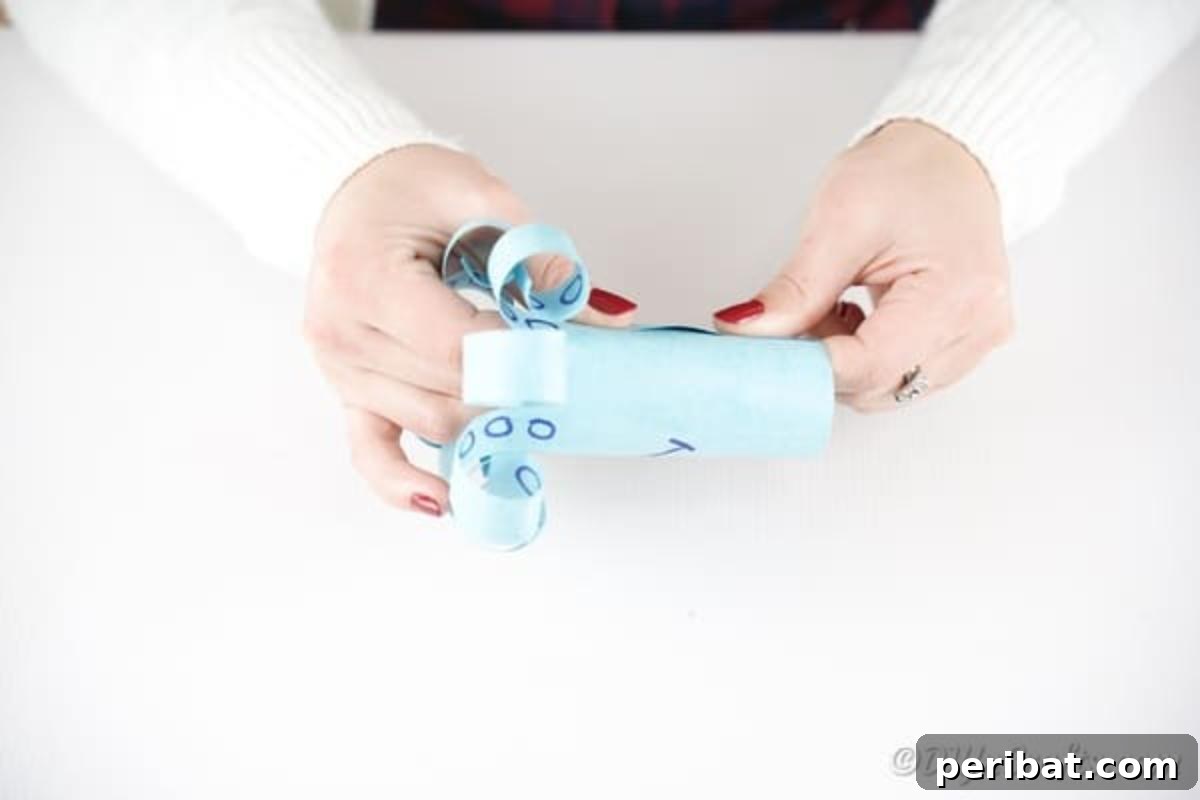 Rolling the blue paper into a cylinder and pressing the glued edges together to form the octopus's body.