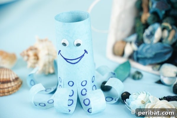 Paper octopus with craft supplies on a wooden table