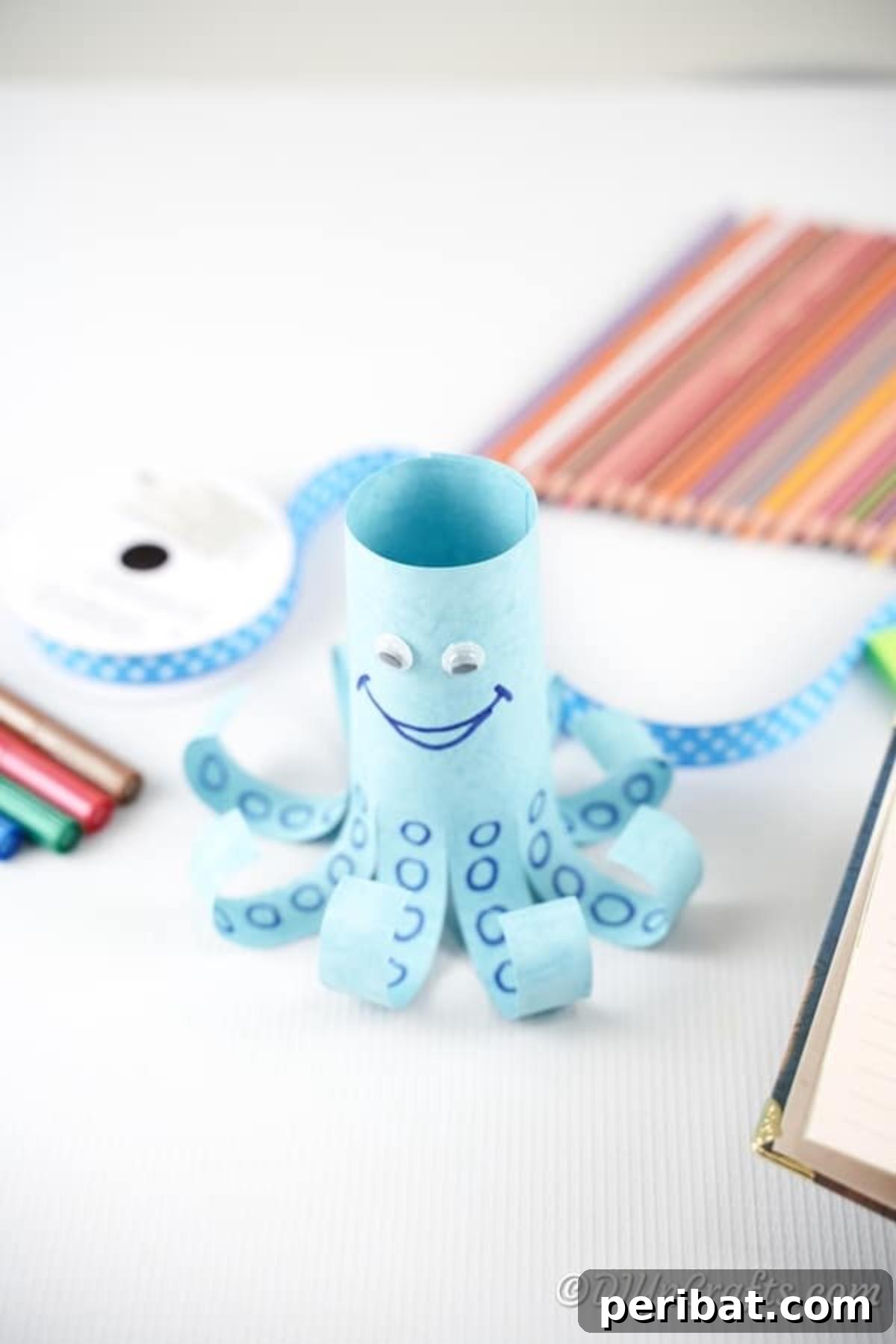 Paper octopus with colored pencils and crafting materials on a table