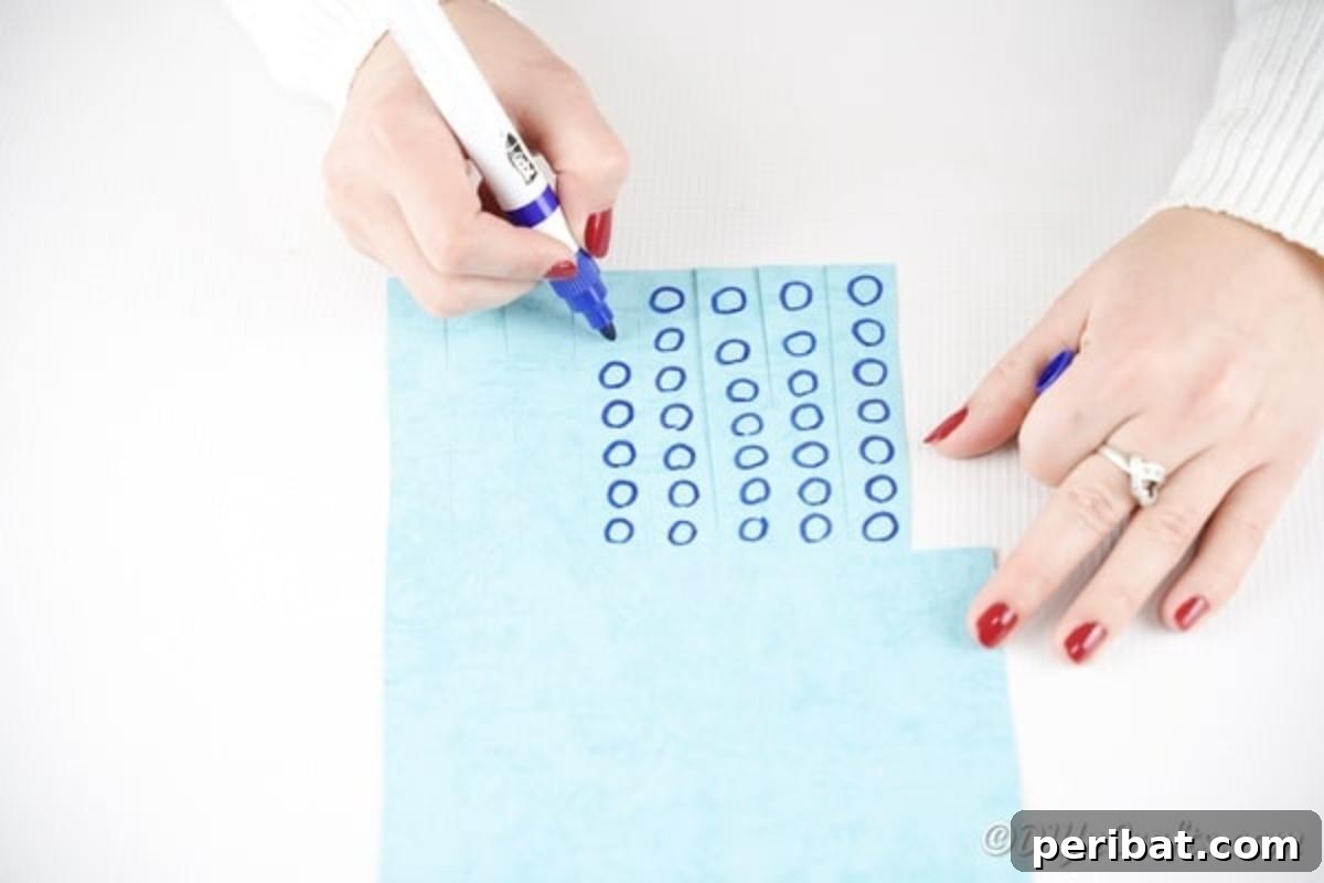 Drawing small blue circles onto the cut paper strips with a marker to create octopus suckers.