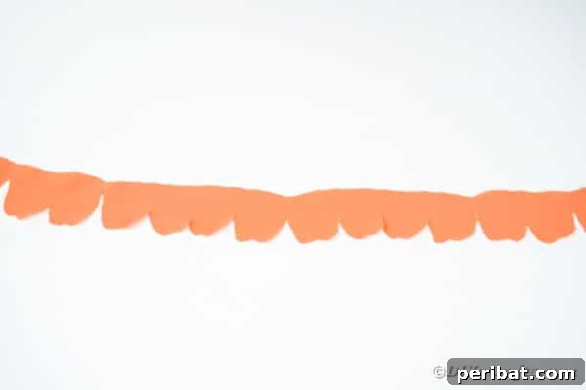 Your Easy Guide to Fabric Flower Bouquets Video 12 Length of orange fabric with a repeating scalloped pattern after unfolding