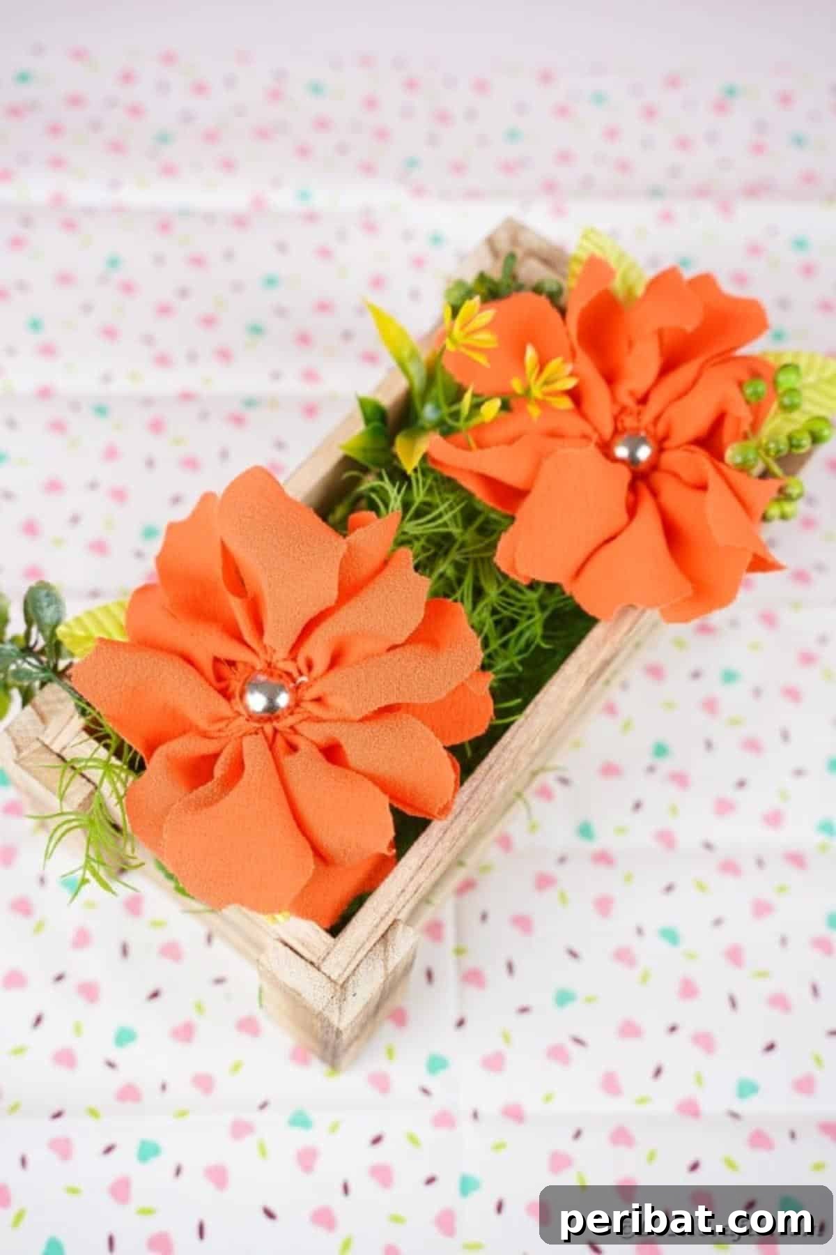 Your Easy Guide to Fabric Flower Bouquets Video 19 Wood box filled with orange fabric flowers on a patterned fabric surface, ready for display