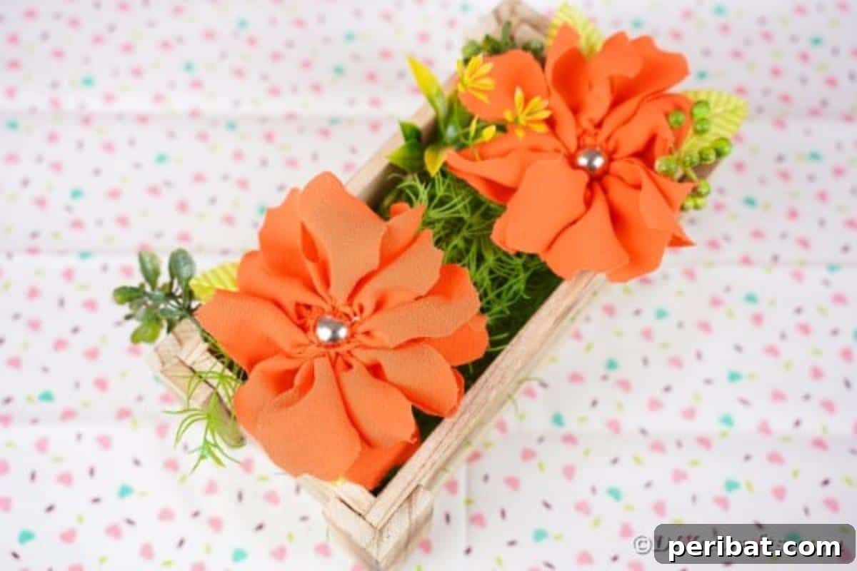 Your Easy Guide to Fabric Flower Bouquets Video 4 Wood box filled with orange fabric flowers on a patterned fabric surface