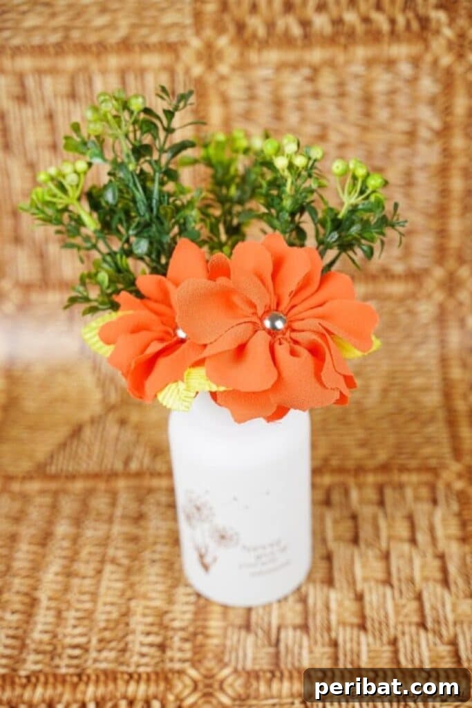 Your Easy Guide to Fabric Flower Bouquets Video 20 Jar of orange flowers with greenery on wood surface, showcasing a completed bouquet