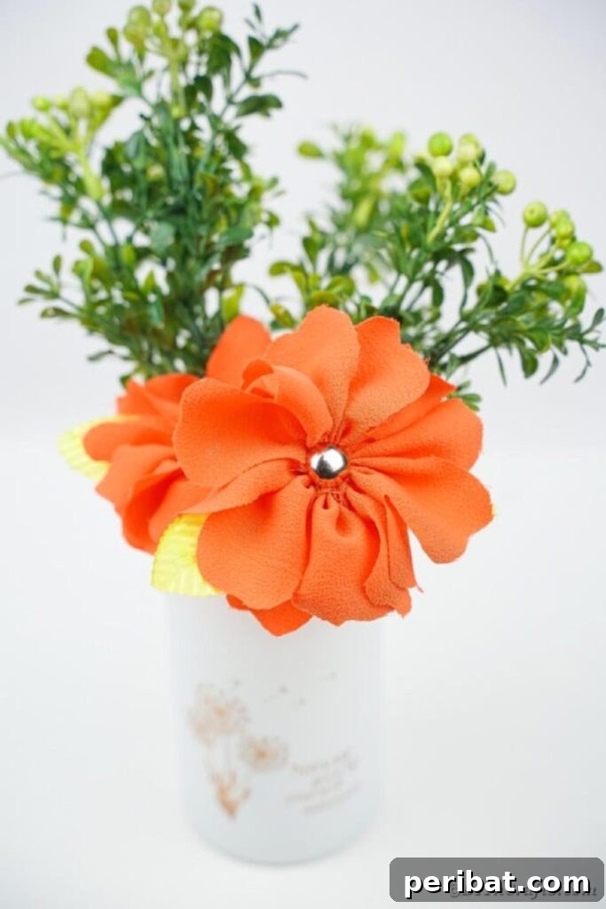 Your Easy Guide to Fabric Flower Bouquets Video 22 Close-up of a vibrant orange fabric flower in a simple white vase