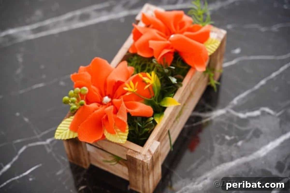 Your Easy Guide to Fabric Flower Bouquets Video 6 Orange flowers arranged in a wood box on a marble table, ready for display