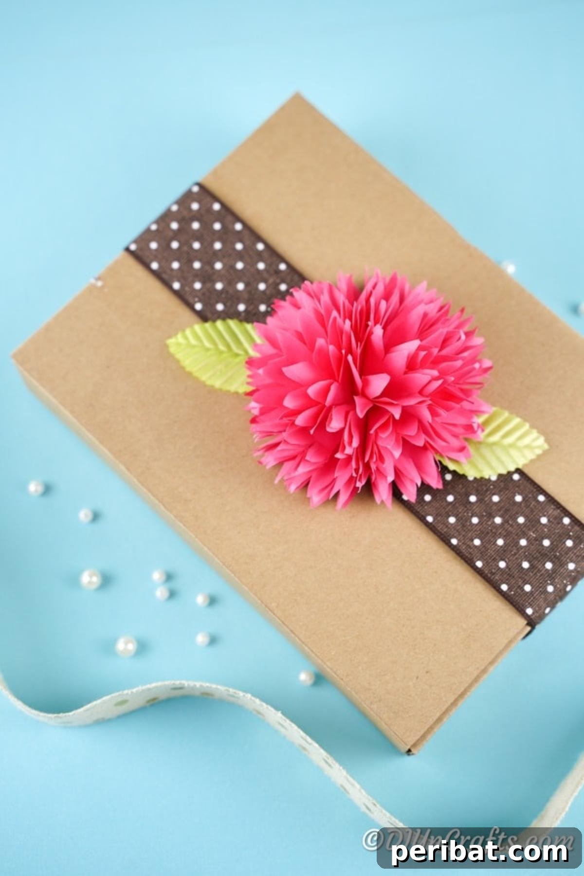 Pink paper flower on top of brown box as gift decor
