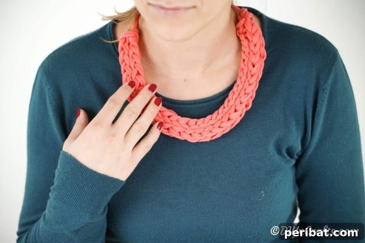 Effortless Elegance: Finger Knit Necklace DIY Video Tutorial 5 A woman confidently wearing a stylish pink finger knit necklace, showcasing how the handmade piece enhances her outfit.