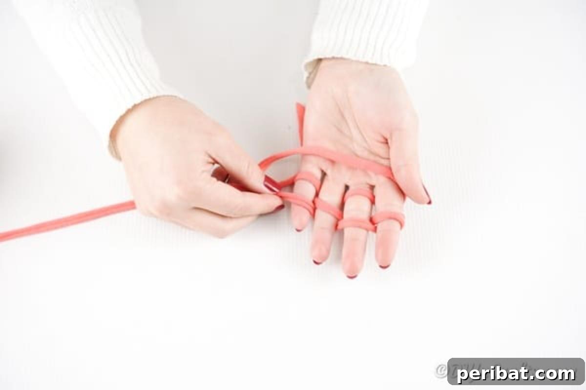 Effortless Elegance: Finger Knit Necklace DIY Video Tutorial 8 Continuing to weave the yarn back between fingers, creating a second set of loops on each digit.