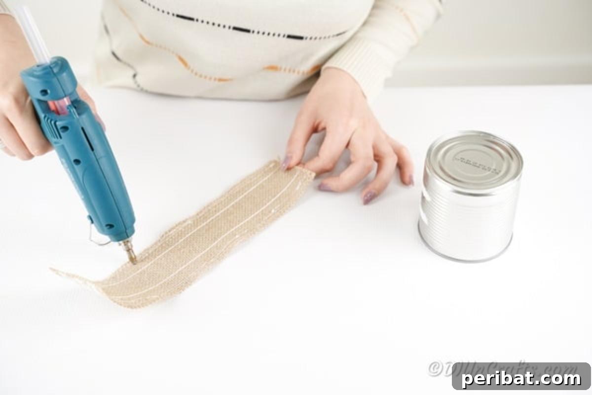 Chic Burlap Lace Accent Canister 9 Applying glue to the back of a burlap strip