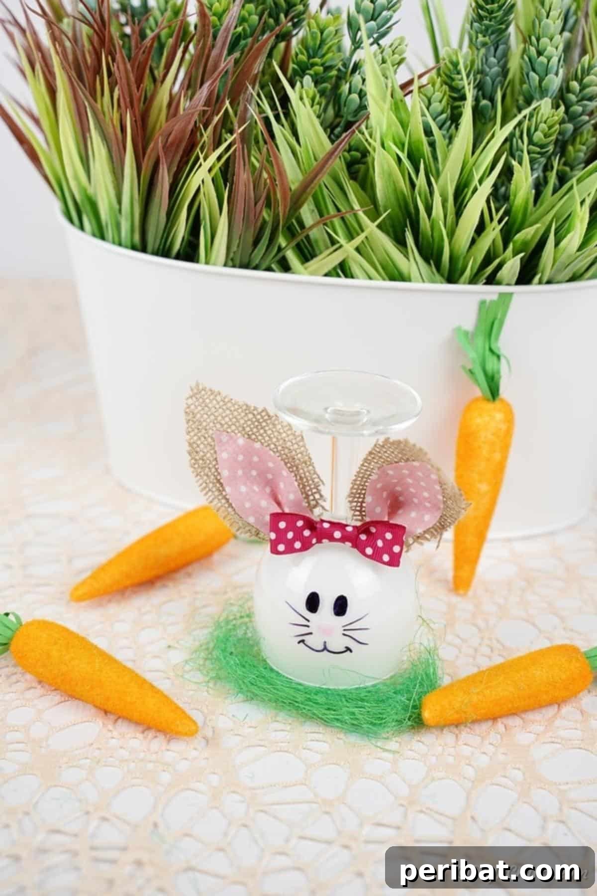 Hoppy Wine Glass Bunny Decor Tutorial 6 A wine glass bunny decoration placed in front of a potted plant.