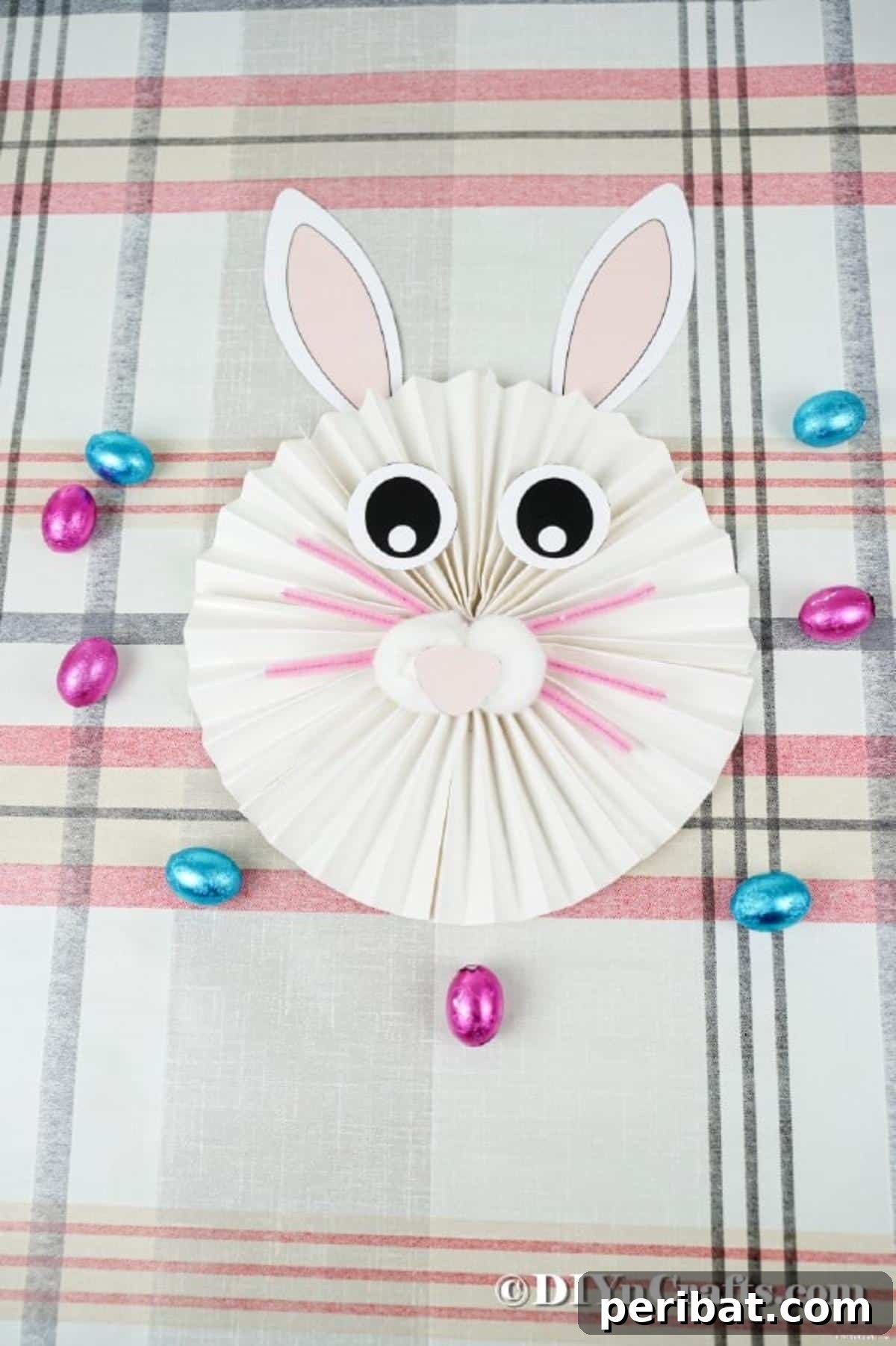 Paper bunny on striped tablecloth