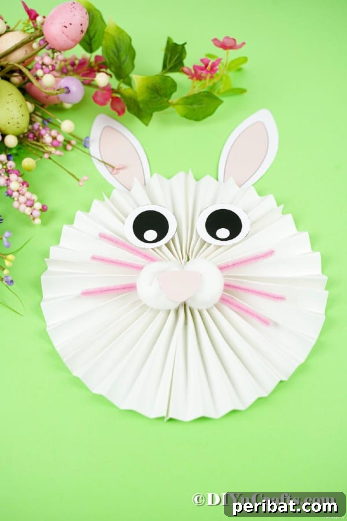 Easter bunny craft on green table by flowers