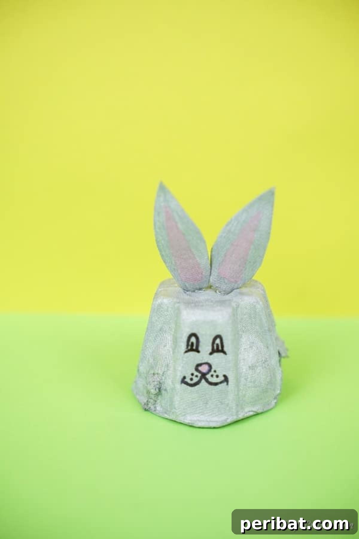 Adorable Upcycled Egg Carton Easter Bunny Craft 14 A completed egg carton Easter bunny sitting proudly on a vibrant green surface, ready to be incorporated into Easter decor.