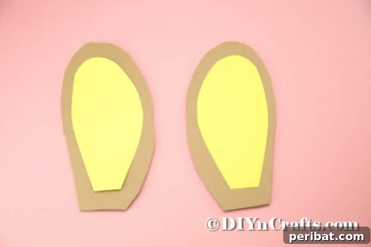 Hoppy Easter Box Ball Toss 18 Gluing the yellow inner ear pieces onto the cardboard ear shapes.