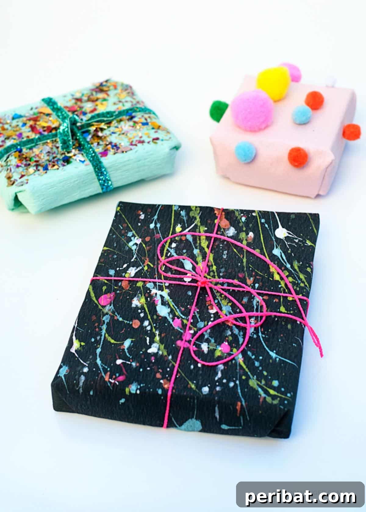 Three uniquely wrapped gifts showcasing a vibrant mix of colors and textures: one with colorful pom-poms, one splattered with neon paint, and one adorned with chunky glitter for a mosaic effect.