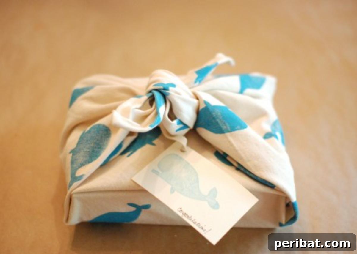 Eco-friendly DIY reusable fabric gift wrap, hand-printed with a charming pattern and tied with ribbon, ready for giving and future use.