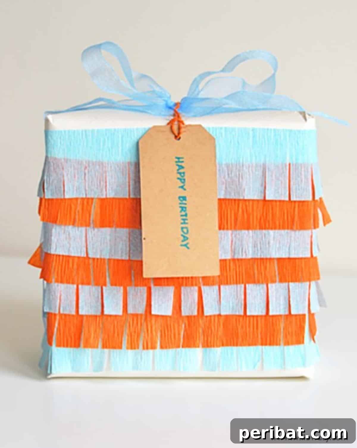 A gift package creatively decorated with vibrant crepe paper fringes, adding a playful, textured, and highly festive dimension.
