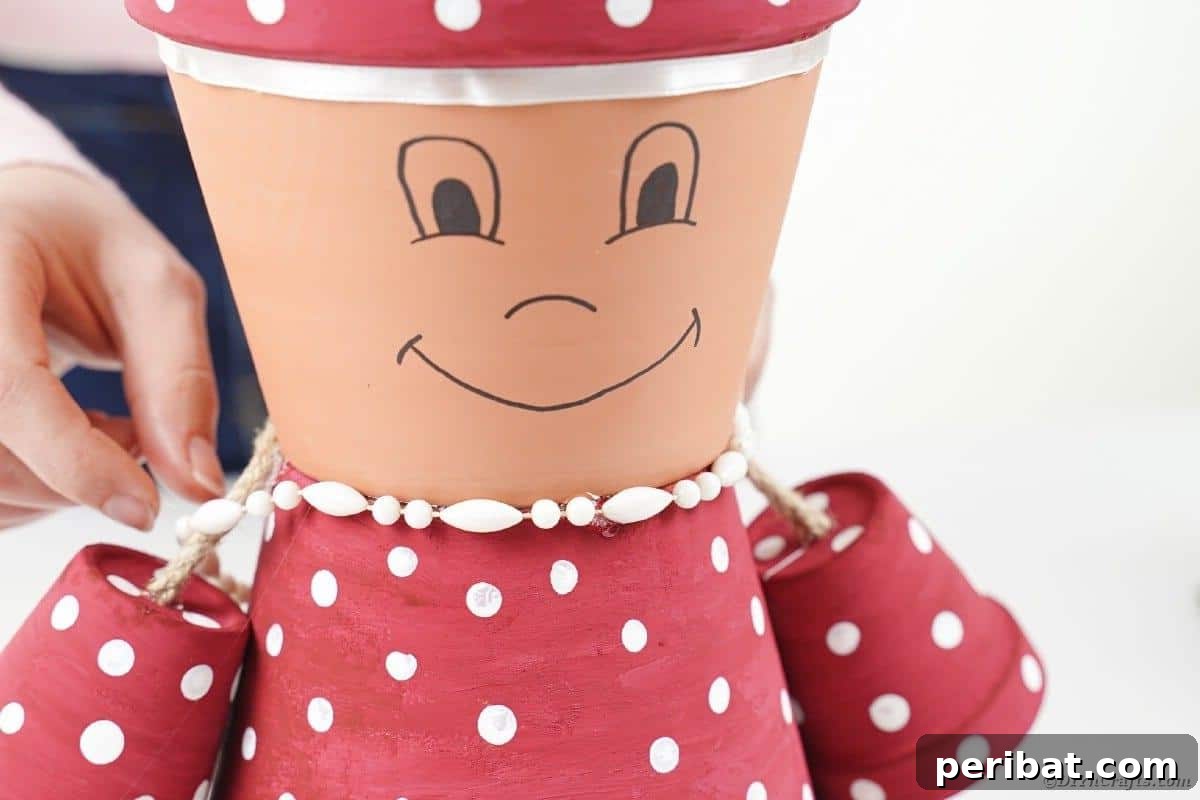 Gluing decorative beads around the neck of the flower pot character
