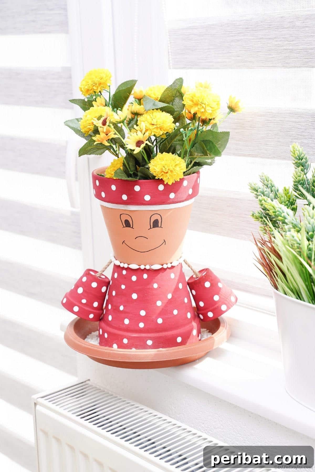 Finished pink polka dot flower pot girl displayed in a windowsill