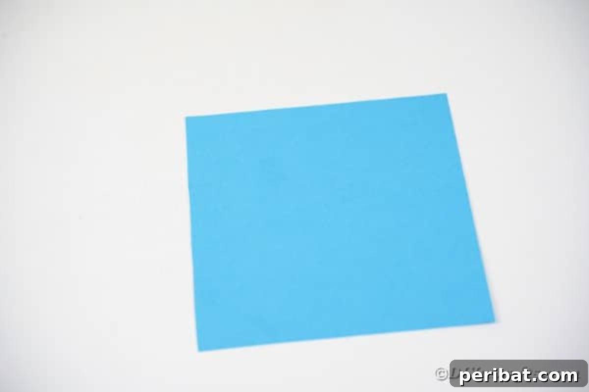 Vibrant DIY Paper Straw Desk Caddy 14 A square piece of blue paper laid flat on a table.