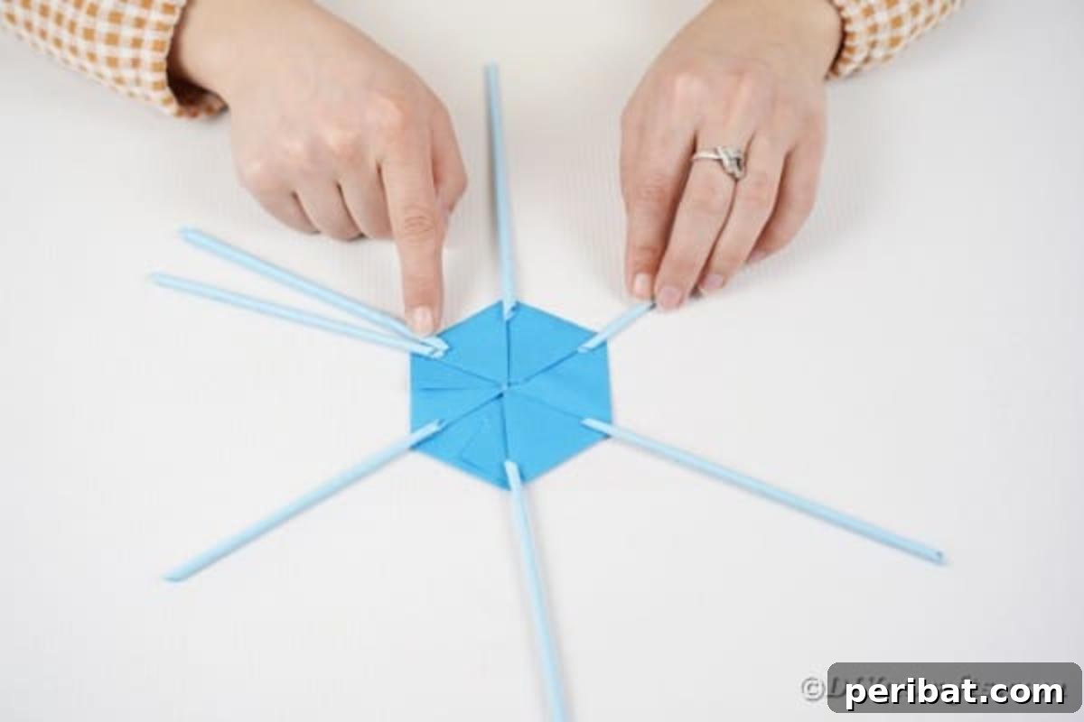 Vibrant DIY Paper Straw Desk Caddy 23 A second paper straw is being glued next to an existing one on the hexagonal base, starting the framework.